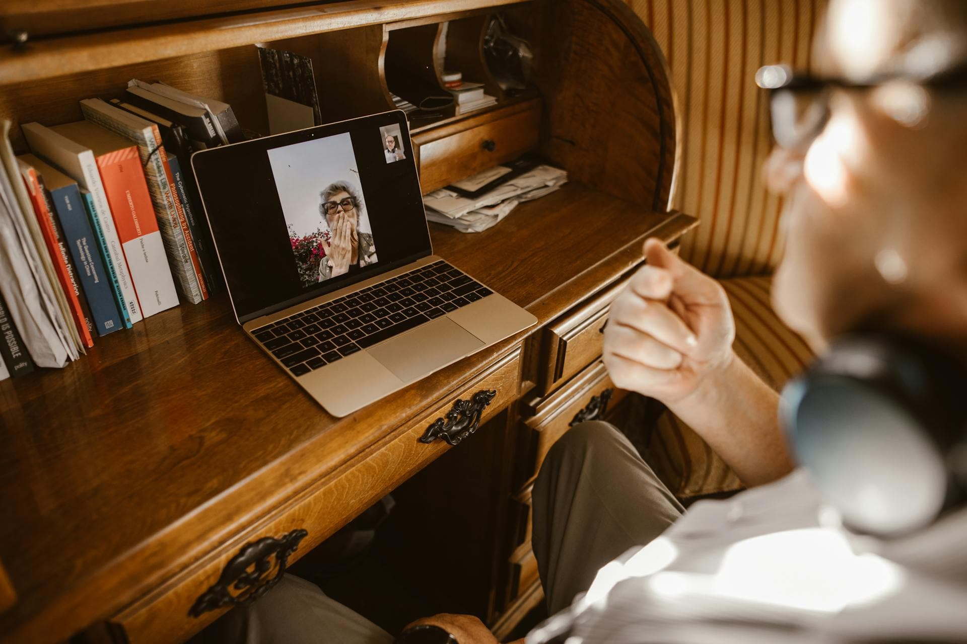 Tay đặt trên laptop hiển thị cuộc gọi video trong không gian làm việc sáng - hợp tác ưu tiên từ xa